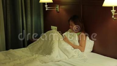 一个年轻的女人在入睡前热情地看书。 夜晚