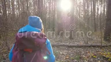 概念冬<strong>季</strong>，秋<strong>季旅游</strong>和徒步旅行.. 一个年轻的徒步旅行者在秋天的森林里徒步旅行