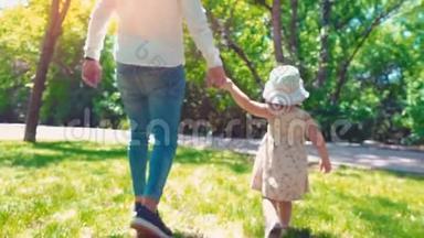 父亲和一个小女儿<strong>牵着</strong>手走在绿色公园里，后景，爸爸和女儿