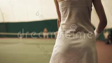 从底部向上的一个积极的女网球运动员用球拍击球的镜头。 网球场