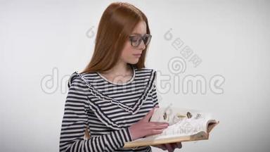 年轻甜美冷静的戴着眼镜的姜姑娘<strong>正在看书</strong>，看着镜头，白色背景
