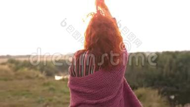 美丽的红头发女子，在美丽的夕阳下，在户外跳舞、旋转和欢笑，享受大自然