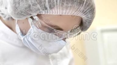 牙科医生用医用眼镜和工作时戴口罩把`的脸闭上.