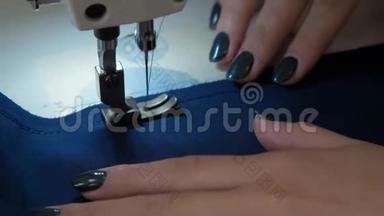 女人`手用缝纫机缝制。 缝纫机针贯穿织物。