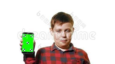 开朗的男孩手里拿着一部智能手机，手里拿着一个绿色的屏幕，屏幕上显示着一个手指。