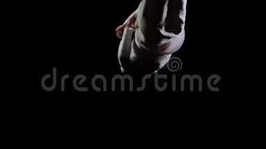 在<strong>蹦床</strong>上的黑色背景上跳跃体操<strong>运动</strong>员。 自由和飞行