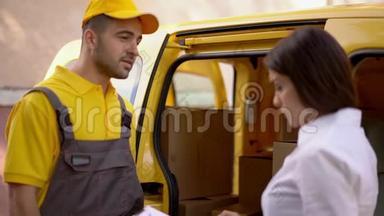 女商人在他的车附近的室外检查由黄色制服的<strong>快递</strong>员<strong>送</strong>货