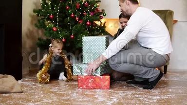 可爱的小女孩<strong>坐在</strong>圣诞<strong>树下</strong>，闭着眼睛，而她的父亲正带着礼盒