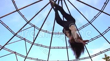 女人倒挂，在空中杂技的擂台上拱起来，顶着天空
