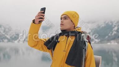 徒步旅行者使用智能<strong>手机</strong>拍摄冬季自然的照片。 游客崇尚自然，<strong>制作</strong>照片.. 年轻人