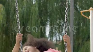 可爱的黑人女孩玩得开心，在院子里上<strong>下摆</strong>动，无忧无虑的童年