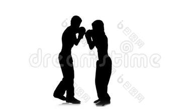 拳击手女孩踢在对手的头上。 剪影。 白色背景。 慢动作