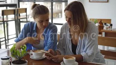 在咖啡馆里约会的女人。 分享她手机上令人兴奋的东西