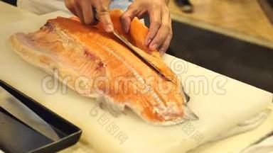<strong>寿司厨师</strong>的特写展示了一个`的能力切片新鲜鲑鱼在<strong>寿司</strong>吧。