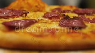 美味的辣香肠披萨放在托盘上。 热辣意大利香肠比萨饼摆在托盘上。 特写