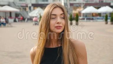 浅棕色头发的年轻女子近距离看镜头的肖像。 城市街头背景的美女。