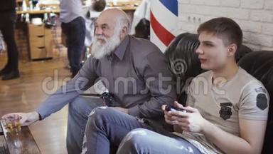 老人和年轻人在理发店等待轮到他们玩电子游戏