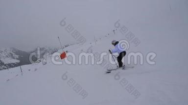滑雪者在冬天的雾中滑下山坡