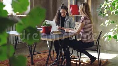 年轻的企业家在现代办公室里坐在桌旁时正在玩弄<strong>广告策略</strong>。 女人在说话