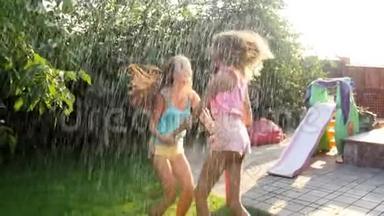 两个十几岁的女孩在后院花园水管溅起的水花下跳舞和跳跃的4k视频