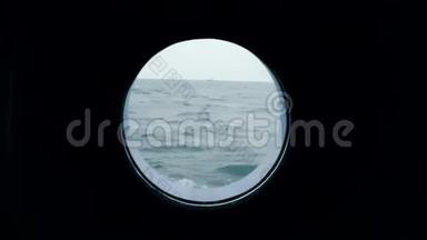 从船的舷窗看海洋。 海洋中的一艘船可以从游轮的舷窗上看到