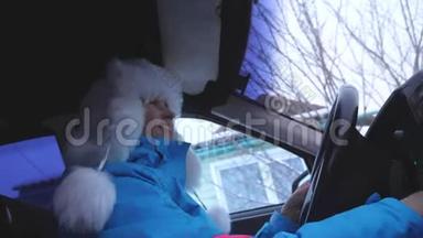 快乐美丽的女孩在开车时跳舞唱歌。 车里的女人笑了。 冬帽<strong>转圈</strong>的女孩