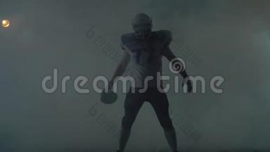 美国足球运动员戴着足球头盔，站在黑色<strong>背景</strong>下的田野上，站在一片<strong>乌云</strong>中