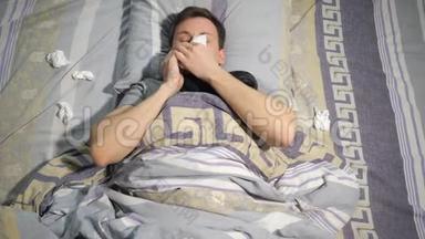 感冒和流鼻涕的病人躺在家里的沙发上用纸巾擦鼻涕