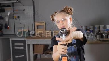 10岁的木木工女的画像，手持电子钻，对着镜头摆姿势。 小小的建筑理念。 高清高清