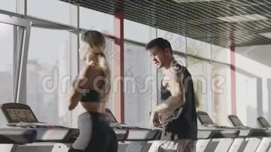 健身情侣一起在健身房的跑步机上跑步