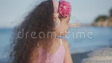 一个留着卷发的可爱的孩子的肖像，穿着粉色衣服穿着粉色花朵的白种人小女孩夏天