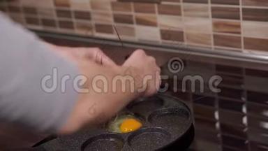 在厨房里用平底锅准备鸡蛋。 全家人的早餐