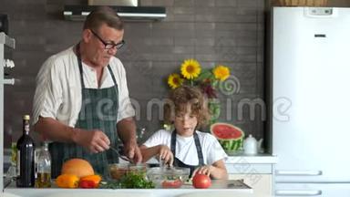 厨房里的人。 儿子切沙拉，父亲在盘子附近<strong>煮汤</strong>。 母亲节。 父亲节`