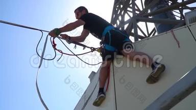 慢镜头拍摄，就像一个人挂在建筑物的屋顶上，拉着绳子，用线锁固定在高处