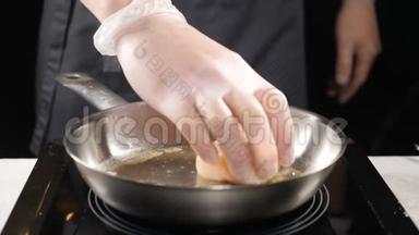 食品艺术。 在餐馆煮海鲜。 职业厨师在手套上缓慢地把扇贝放在煎锅上。 <strong>高清高清</strong>