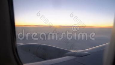 傍晚日落时分，一架客机在云中飞行，从窗外景色。