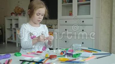 快乐的小女孩玩<strong>橡皮泥</strong>，用手滚球，数字和彩色铅笔躺在桌面上