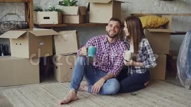 女朋友和男朋友正在谈计划，坐在新买的公寓地板上，<strong>四处</strong>看看，