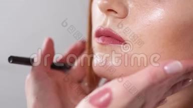 化妆师双手`特写镜头，双手在嘴唇上化妆
