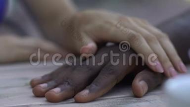 高加索女人牵着她的非裔美国男友的手，温柔