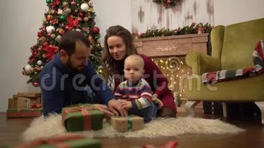 妈妈、爸爸和小宝宝坐在房间的地板上，<strong>一家人</strong>一起庆祝<strong>圣诞节</strong>