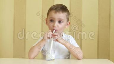 一个快乐的孩子通过吸管从杯子里喝牛奶，表现出快乐和一只手的拇指。