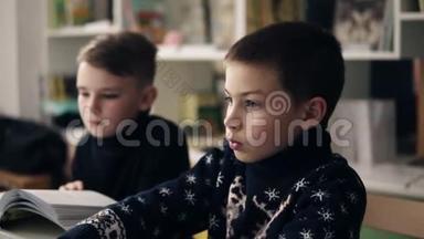 两个小男孩坐在笔记本电脑前的慢镜头。 编程课。 替代教育