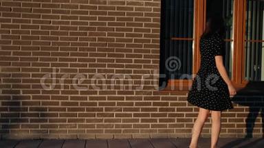一个年轻的女人在城市里走来走去，停在窗边看她的倒影。