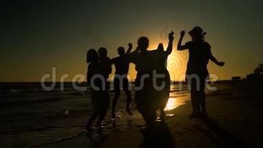 欢<strong>乐</strong>的人群在海滩上跳舞。 他们在阳光下跳跃。 人们玩得很<strong>开心</strong>。 他们很<strong>开心</strong>。 人的剪影