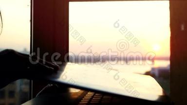 在美丽的日落`，女人的手在笔记本电脑`键盘上打字，有着强烈的闪光效果。 3840x2160