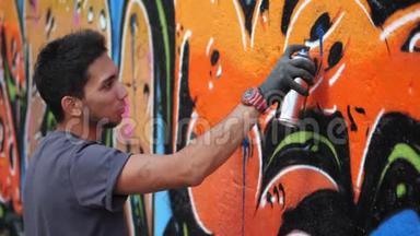 <strong>街头</strong>艺术家在普通墙上画彩色涂鸦-现代艺术理念与城市人<strong>表演</strong>和准备
