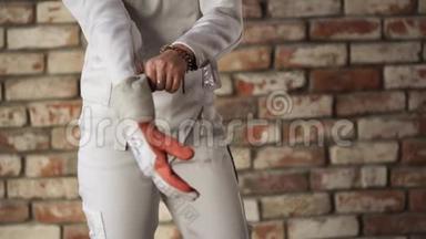 年轻击剑运动员戴着运动服手套，准备参加比赛