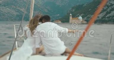 在船上恋爱的情侣。 从后面看，男人和女人在坐在船上骑马时互相拥抱