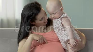 孕妇<strong>抱着婴儿</strong>，指<strong>着</strong>肚子，<strong>婴儿</strong>往下看